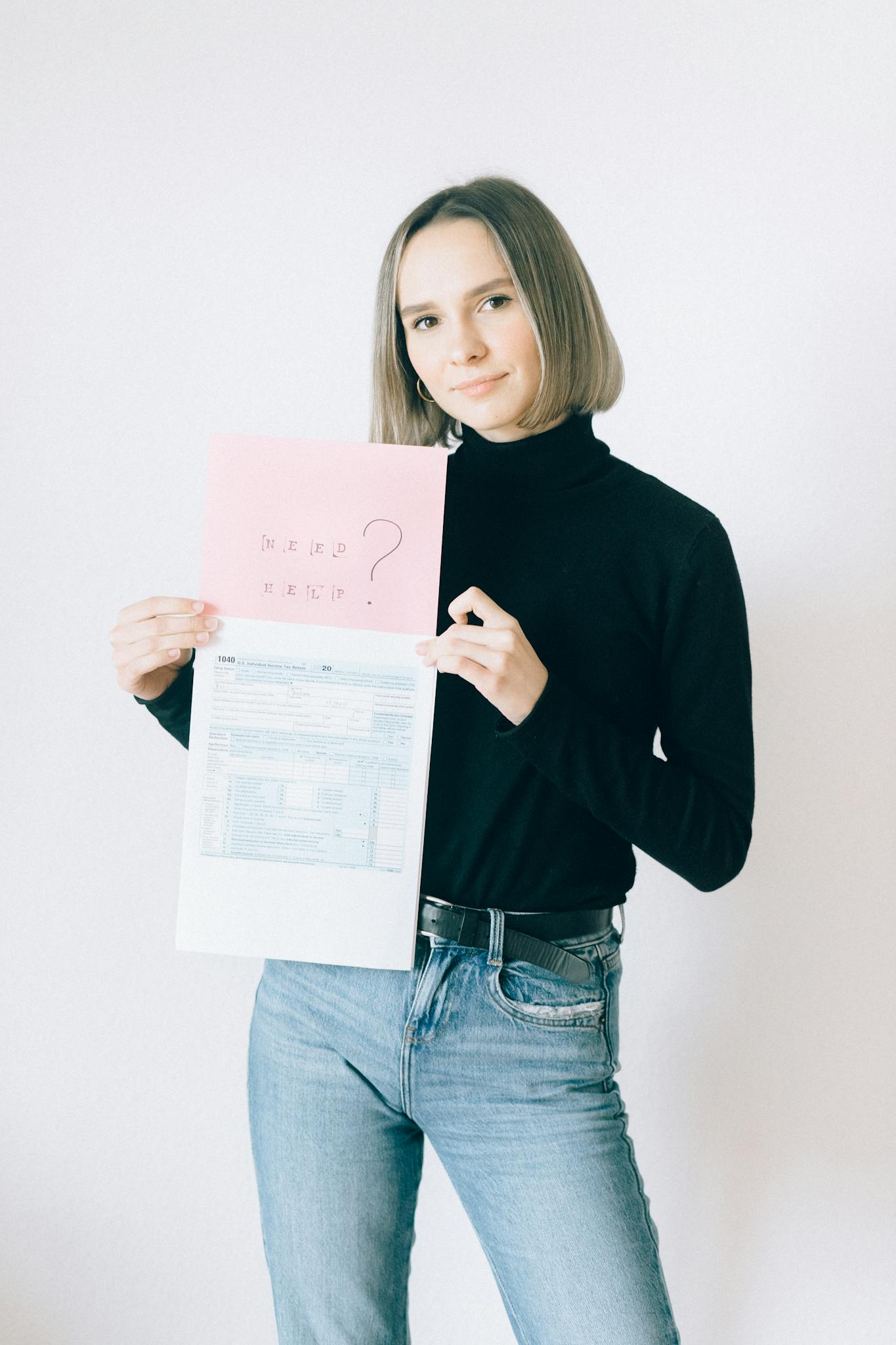 Young woman with paperwork holding tax forms and question sheet.